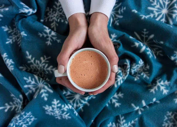 woman a cup of hot chocolate on a wool blanket