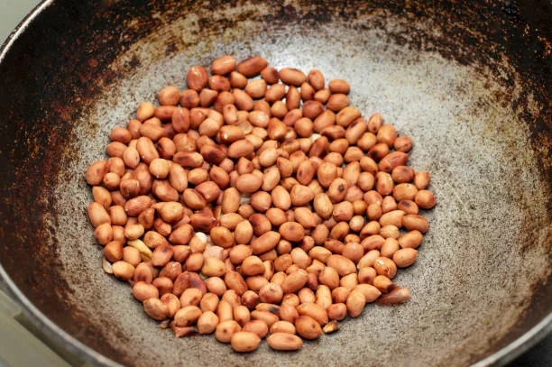Roasting peanut in a frying pan, Maharashtra, India