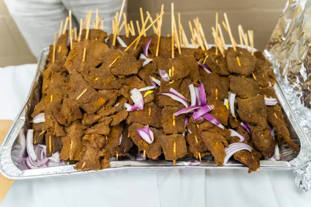Nigerian pepper beef suya on stakes at party a popular snack